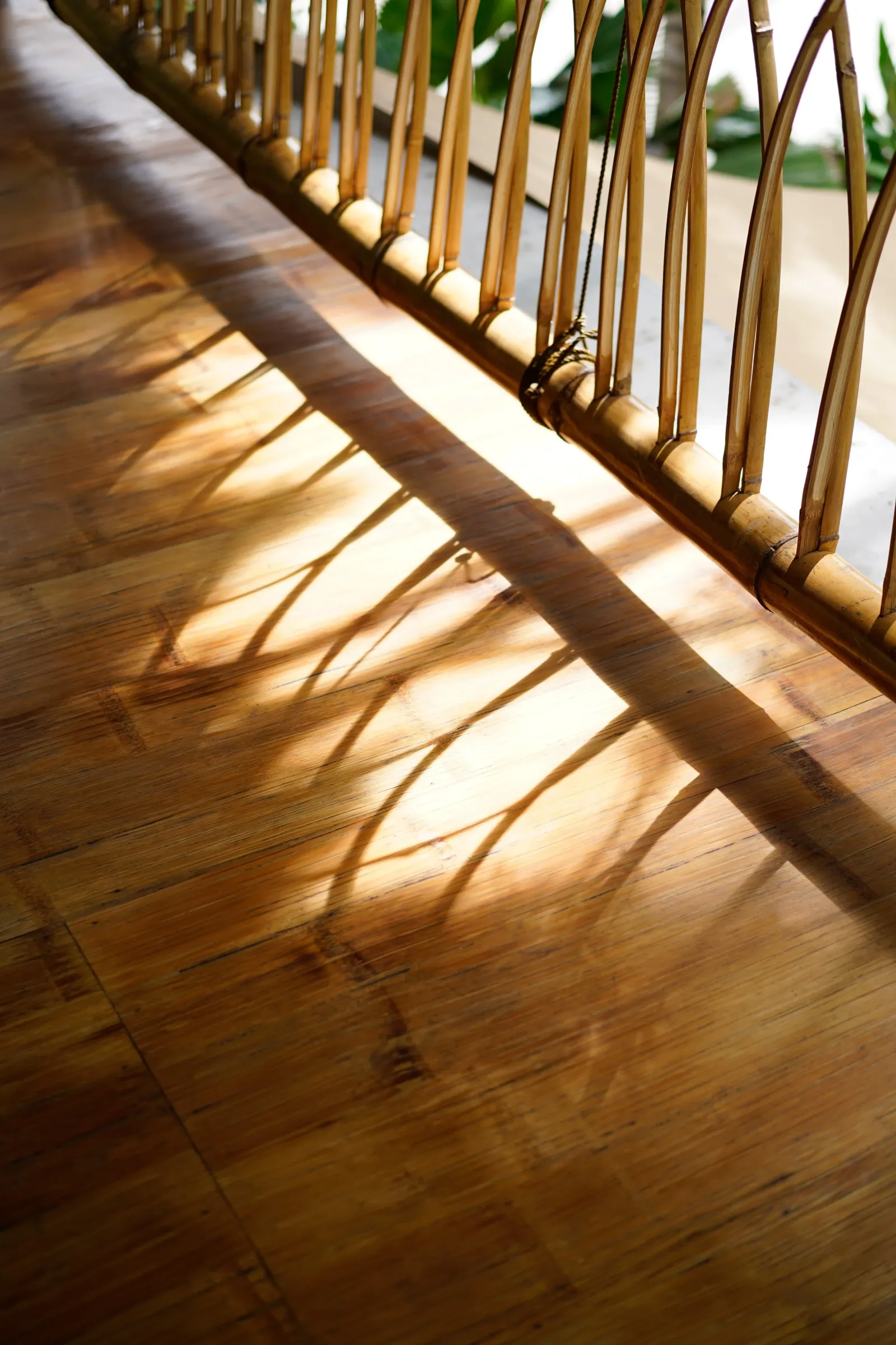 Sunlight across the bamboo railing and wooden floor at Anahaw Dauin
