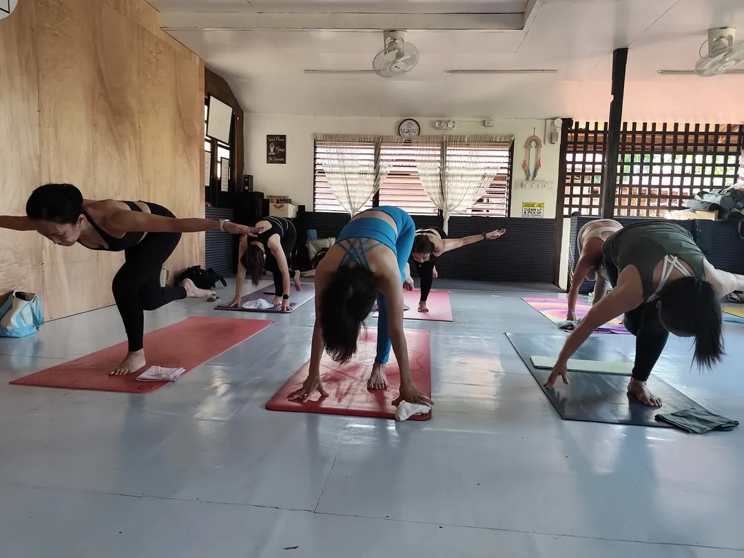 Students in a standing balance across the wide practice room at Balay Yoga