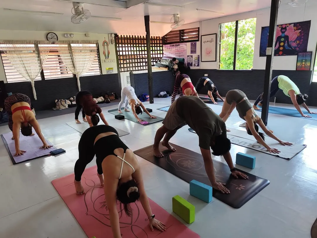 A class in downward dog on coloured mats at Balay Yoga