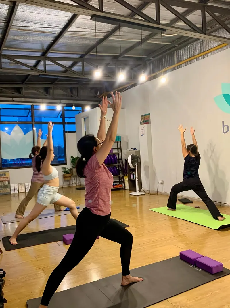 Students in warrior pose with blocks in the window-lit studio at Bliss Yoga Cebu