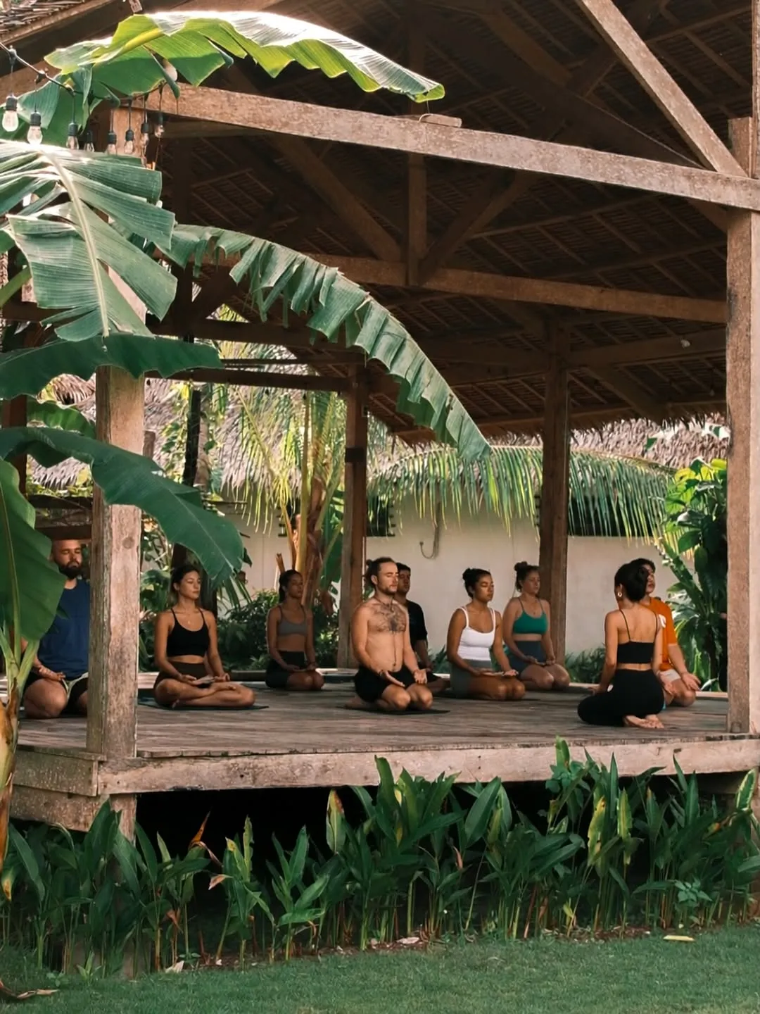 A class seated in meditation in the raised garden shala at Buddha Wellness Siargao