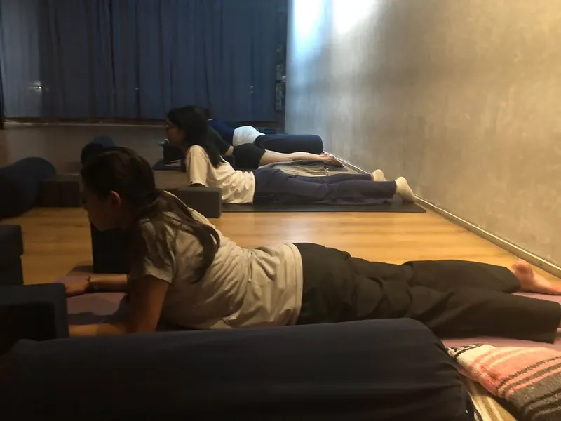 Students resting on bolsters in a restorative class at ComFit Studio
