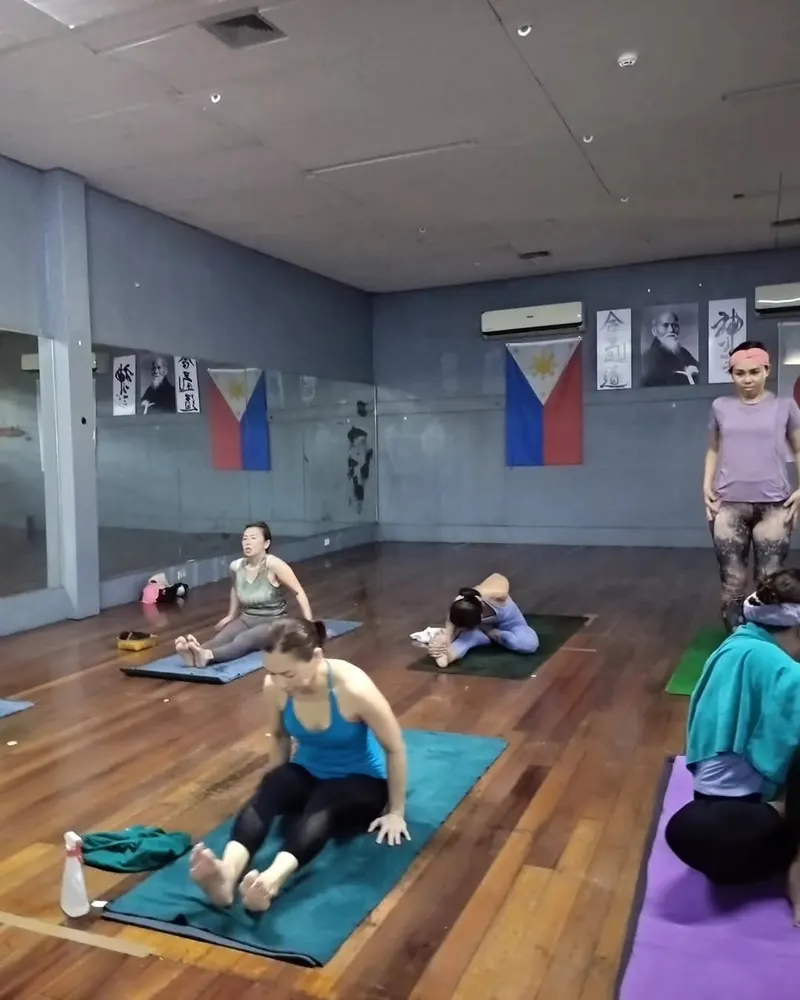 An Ashtanga class practising on the wooden floor of the Ekam Yoga Center room