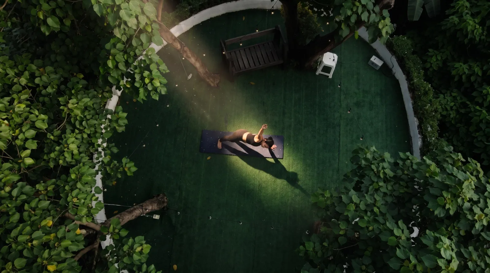 An overhead view of the tree-ringed garden practice area at Indian Yoga School PH