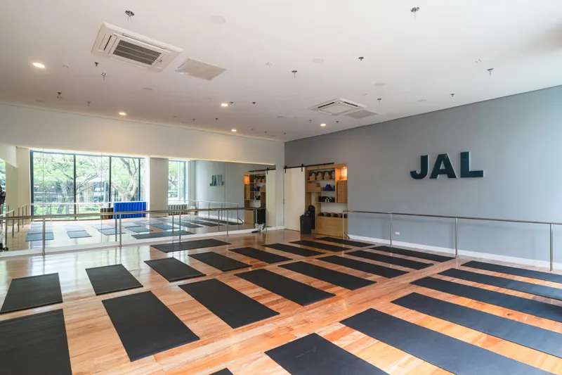 The main practice room at JAL Yoga with mats laid out on a wooden floor
