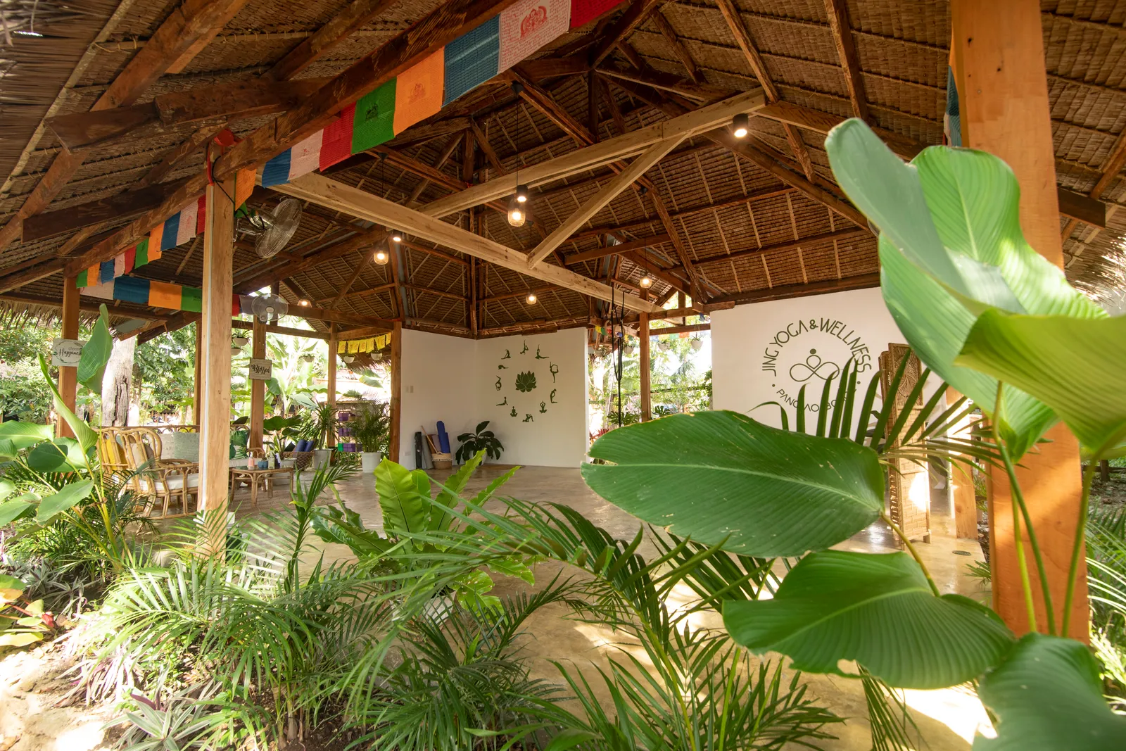 The thatched shala at Jing Yoga and Wellness framed by tropical plants