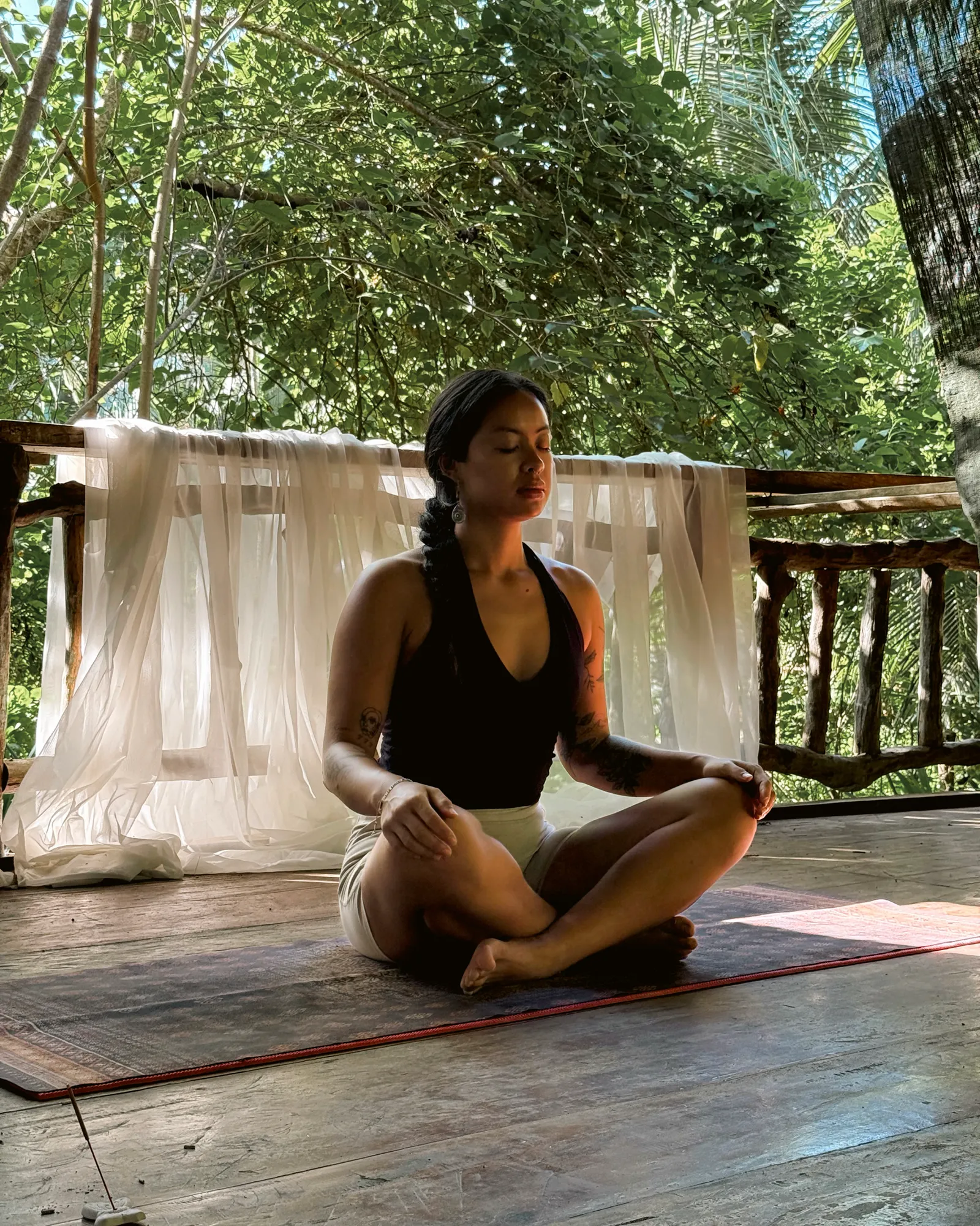 A Kinaiya teacher seated in meditation on the open-air shala floor