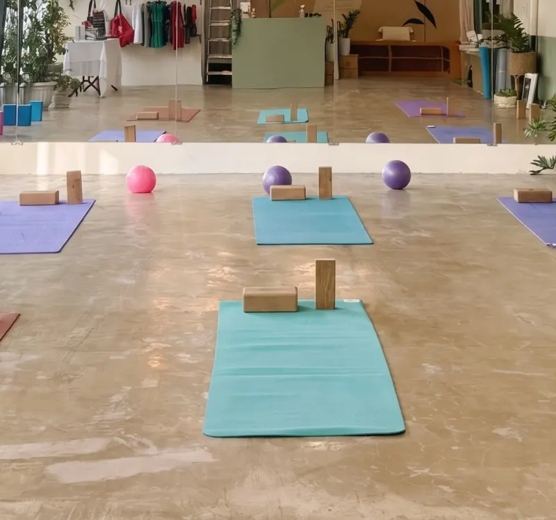 Mats, blocks and balls set out on the floor of a Love Yoga World studio