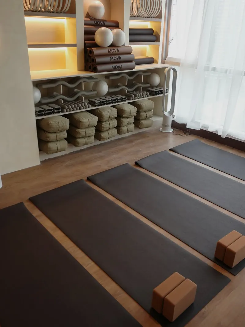 Studio with dark mats and blocks laid out beside lit shelves of props