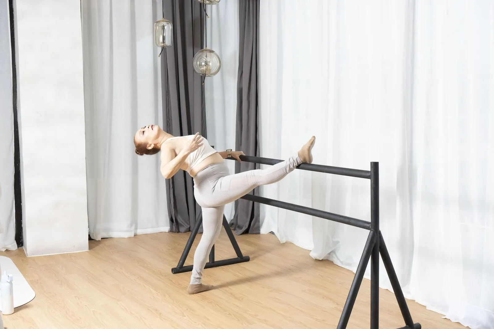 Dancer stretching at a ballet barre in the studio