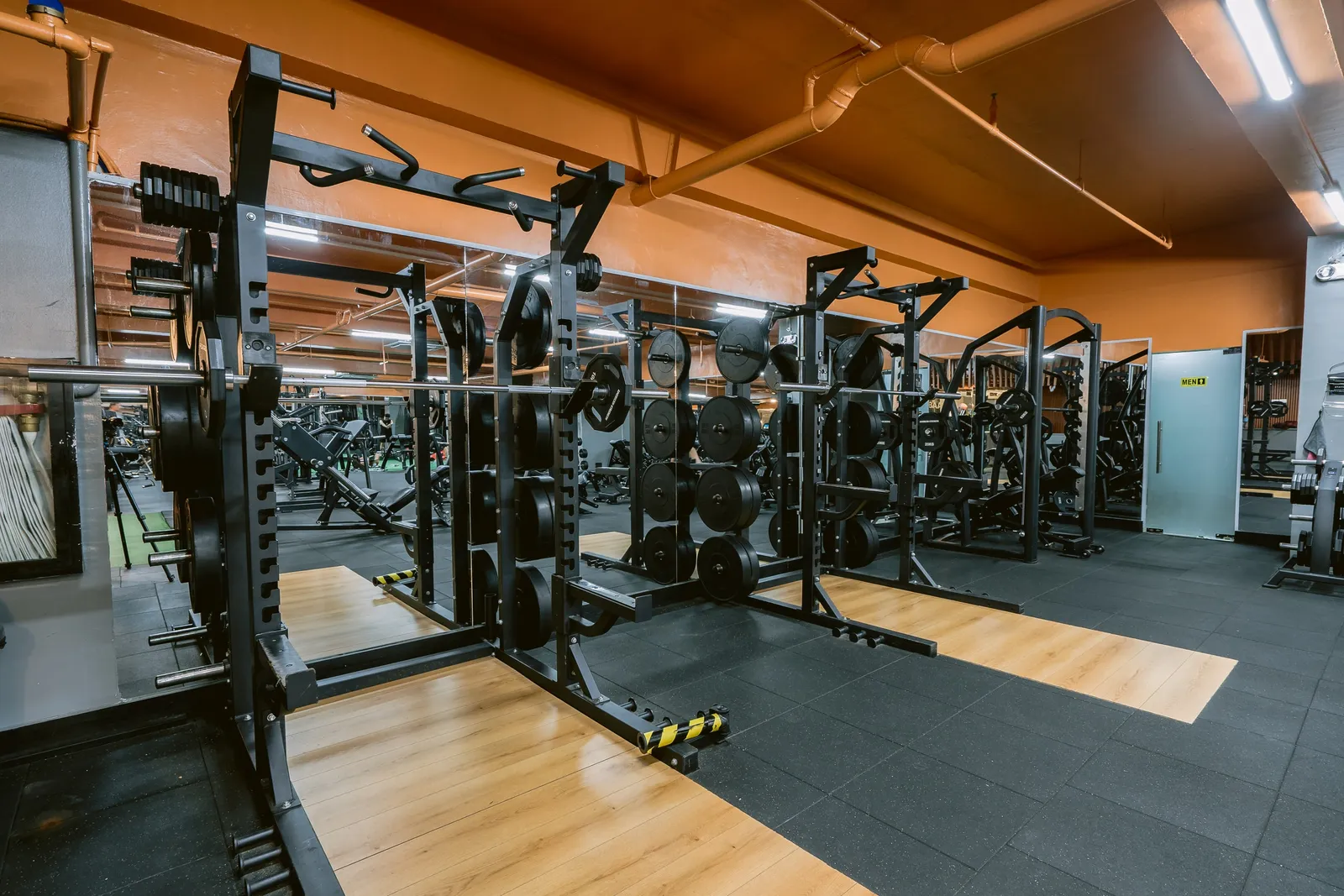 Strength training area with squat racks and a wooden lifting platform