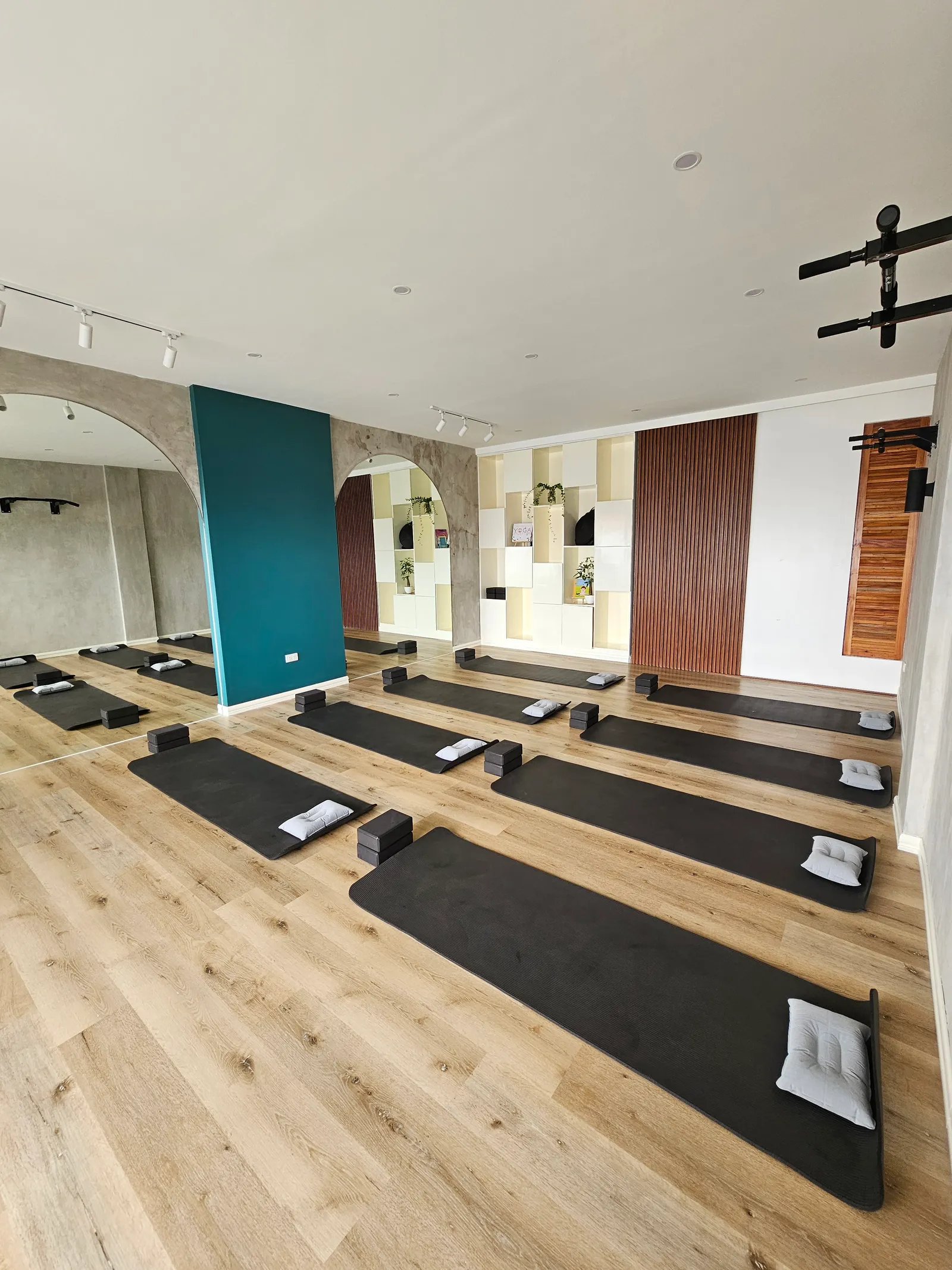View from above of the studio with mats and bolsters lined up on a wooden floor
