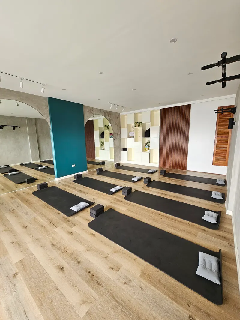 View from above of the studio with mats and bolsters lined up on a wooden floor