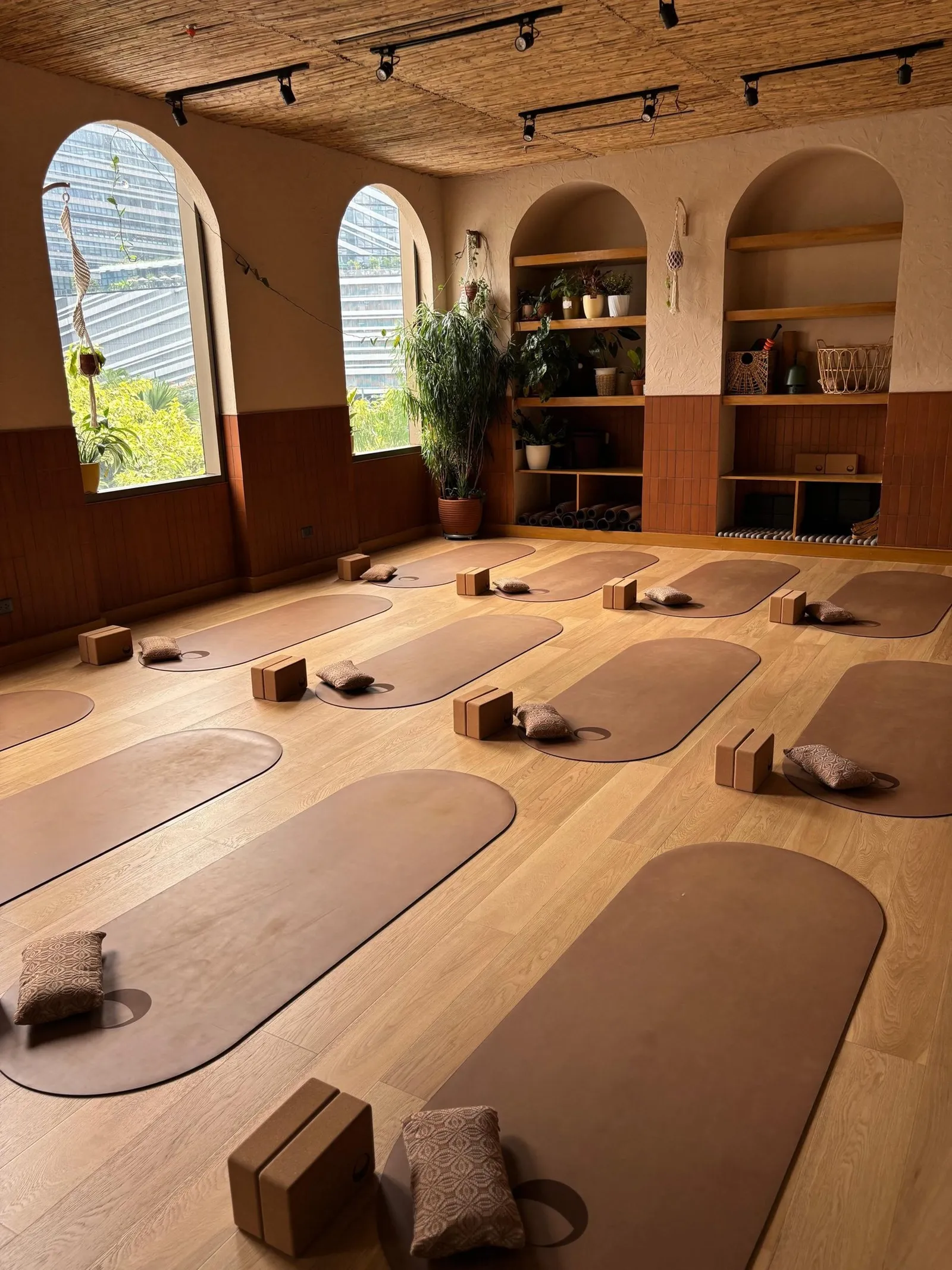 Studio room with arched windows, wooden floor and mats with blocks laid out