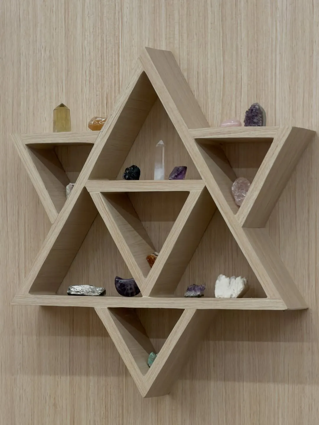 Star-shaped wooden wall shelf holding crystals