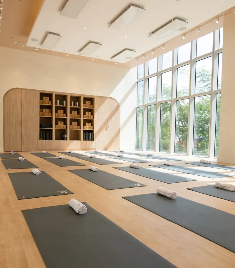 Bright studio with tall windows, wooden floor and mats laid out