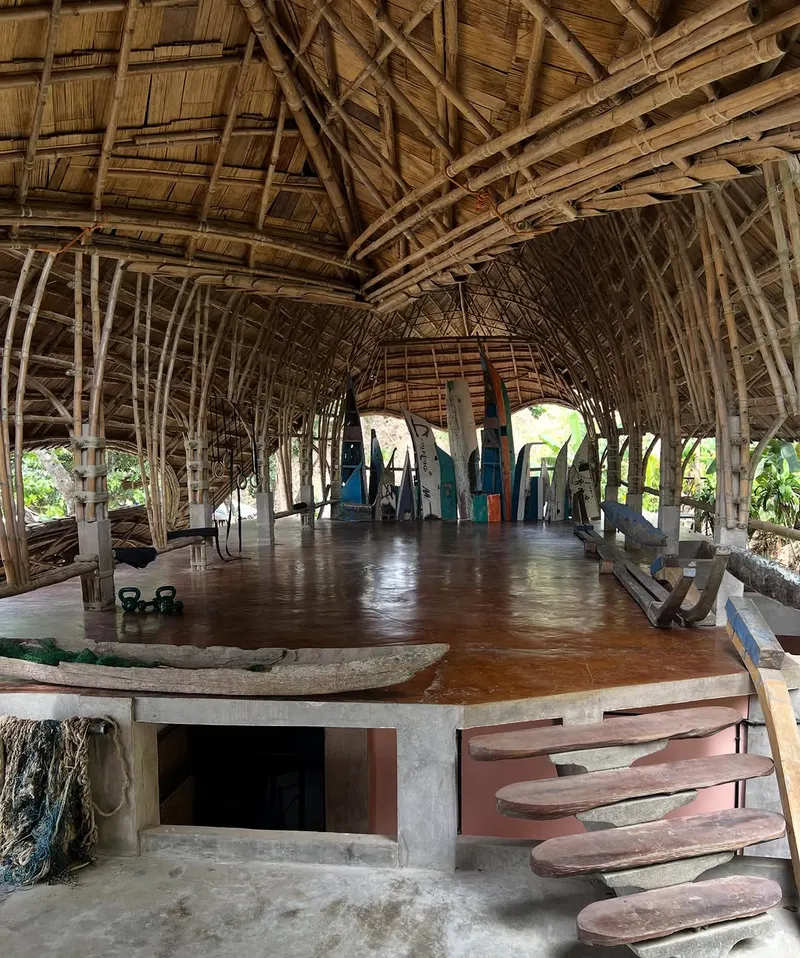 Open-air bamboo pavilion with a wooden floor and curved roof