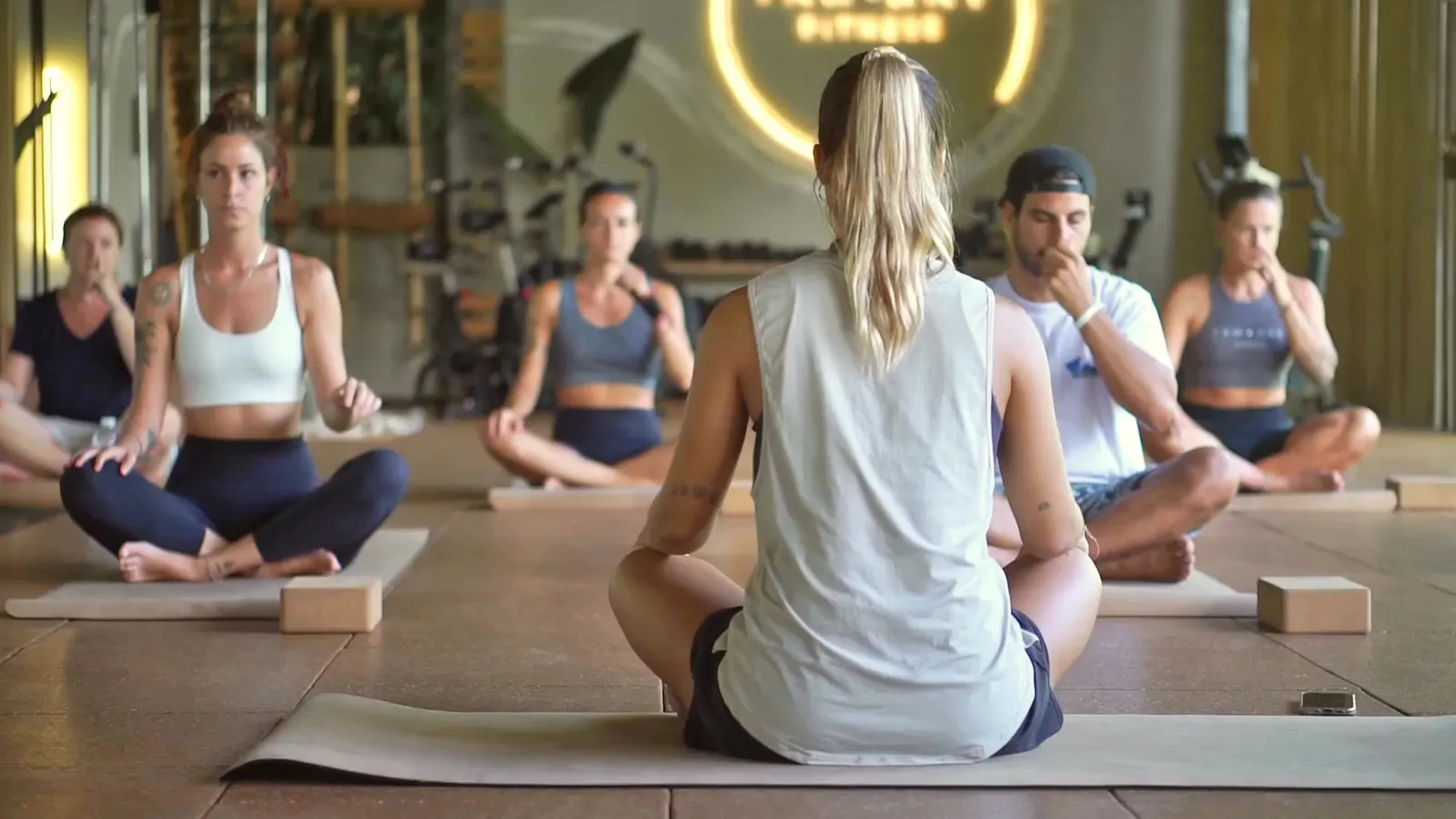 Seated yoga class on mats with blocks in the studio