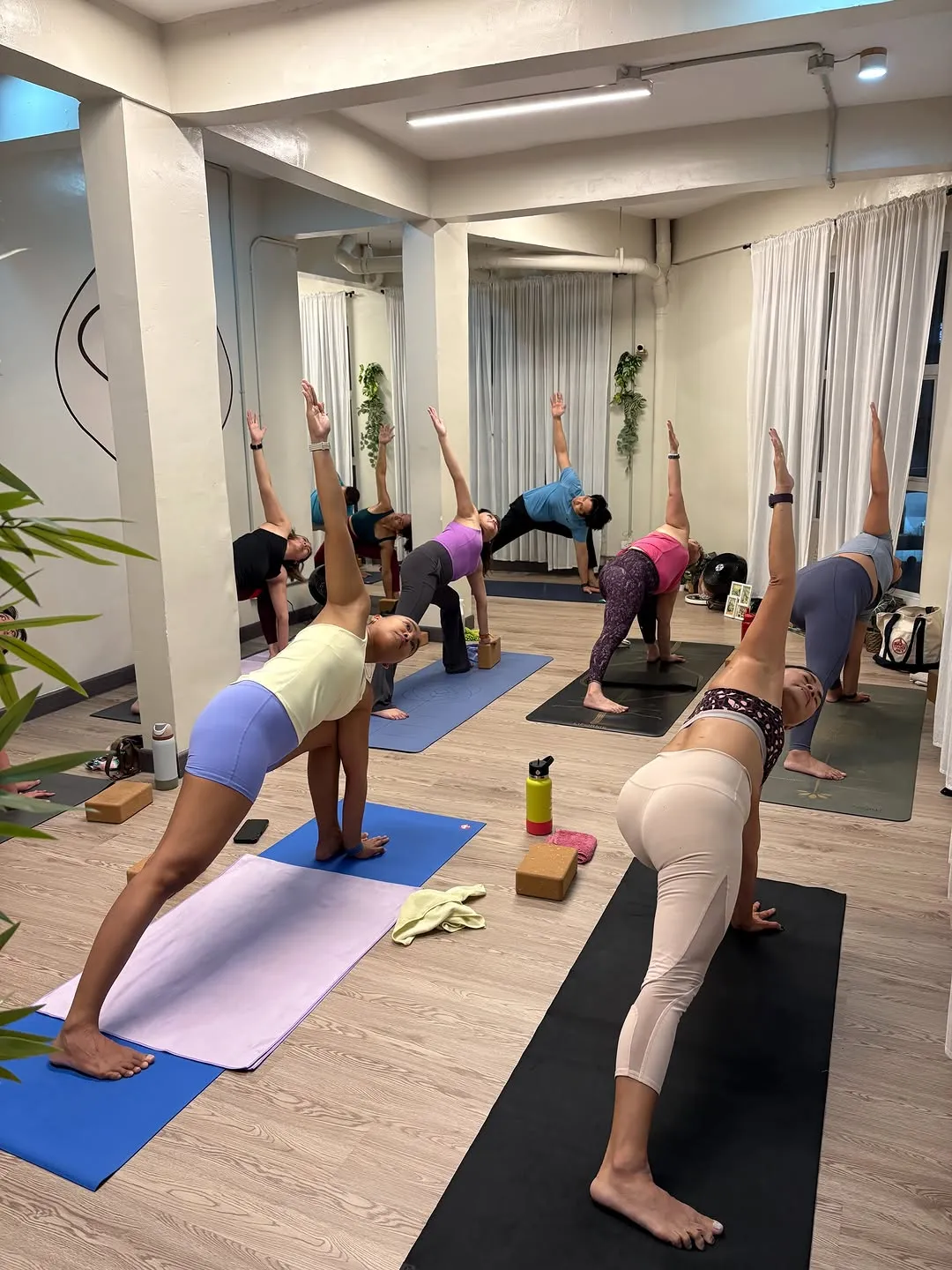 Class in downward dog variations on mats in the studio